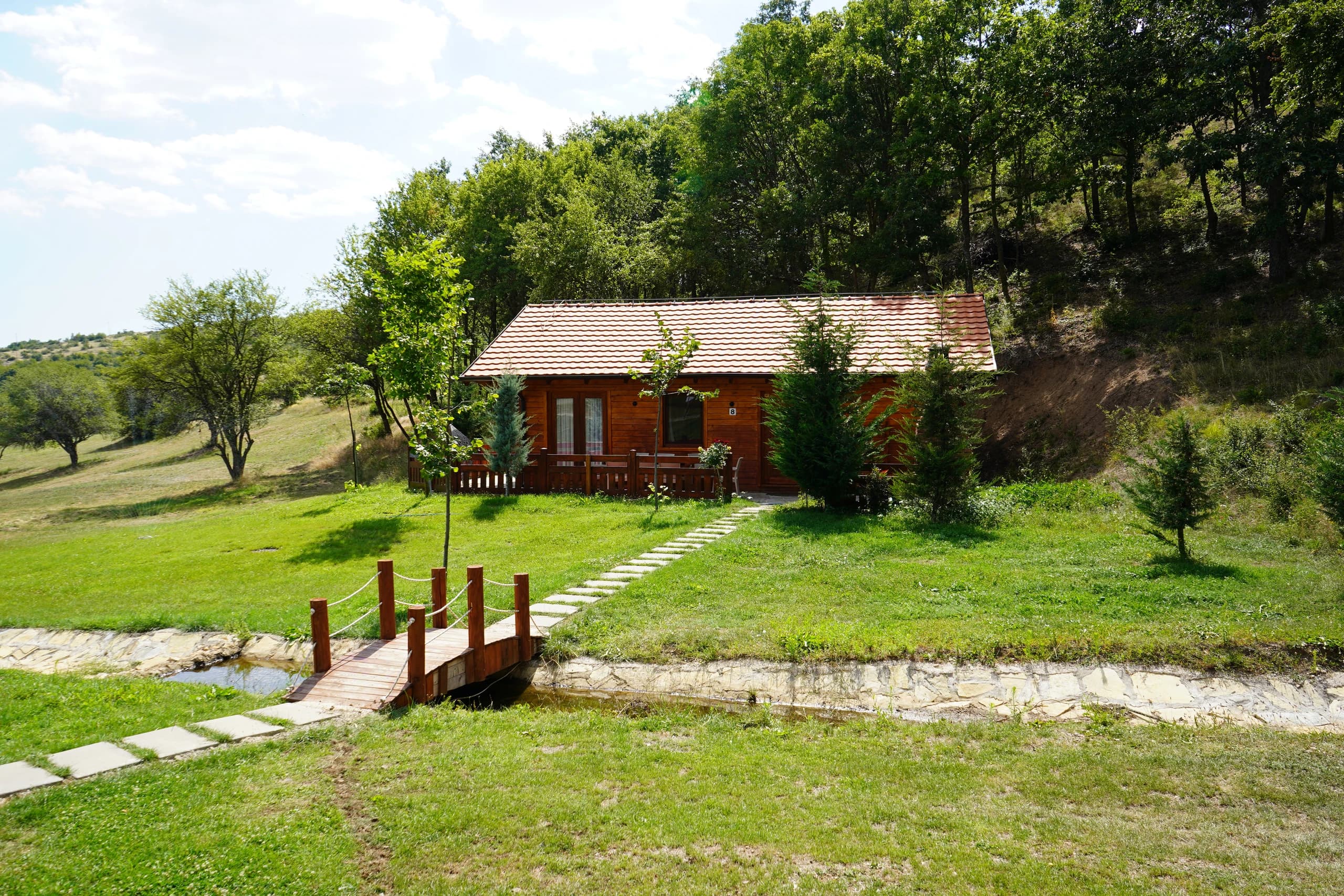 The footbridge over the stream below the villas